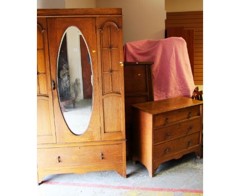 A VINTAGE OAK THREE-PIECE BEDROOM SUITE comprising mirrored single wardrobe with base drawer, three-drawer chest and pair of 