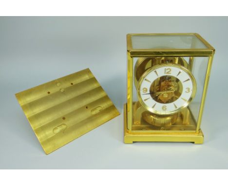 A JAGER LECOULTRE ATMOS CLOCK in a gilt brass and glass case having a white chapter ring with gilt numbers and hour batons an