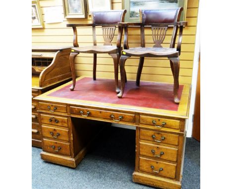 A LARGE VINTAGE OAK PARTNER'S DESK having nine drawers and single cupboard and single drawer verso with red leather writing s