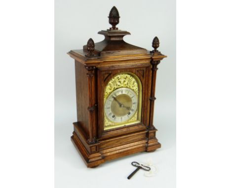 A WINTERHALDER AND HOFFMEYER BLACK FOREST ARCHITECTURAL BRACKET CLOCK in oak with brass dial and silvered chapter ring bearin
