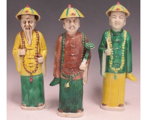 Three ceramic Chinese standing figures in mainly green and yellow, tallest figure, 23cm (3)all three figures have chips to th