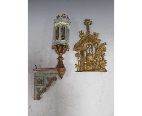 A gilt metal hanging relief of bears stealing honey from a hive, together with a painted metal baroque style wall bracket