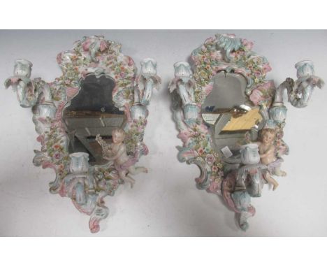 A pair of Dresden three-branch wall mirrored wall sconces, the rocaille frames applied with putti and garlands of flowers, 46