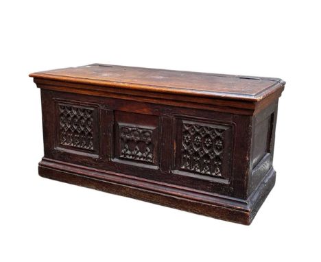 An triple panelled oak chest, incorporating Elizabethan elements, with hinged lid, the front with central carved panel depict