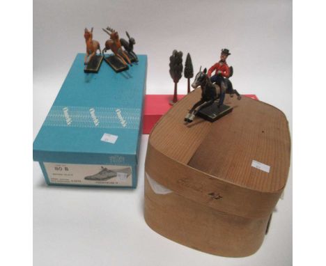 A vintage painted wooden model hunting set, the animated figures fixed on a trembling wire above each plinth, with hare, deer