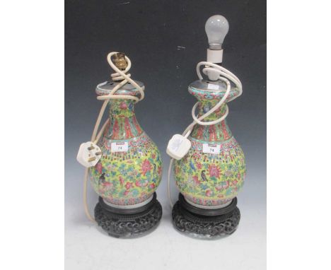 A pair of Chinese famille rose vases Republic period, adapted as table lamps, decorated with fruits and flowers on carved woo