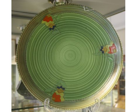 A Crown ducal Charlotte Rhead style green glazed circular pottery charger, painted with stylized flowers and leaves, Dia: 32c