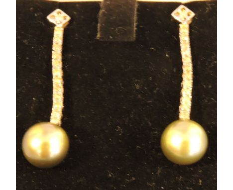 A pair of white gold diamond set drop earrings each set with a natural pearl