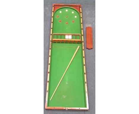 An early 20th century mahogany folding tabletop bagatelle game with cue, instructions and 'arches with numbered pockets', fro