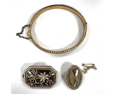 A hallmarked 9ct gold bangle, together with two brooches tested as 9ct gold, gross weight 22g
