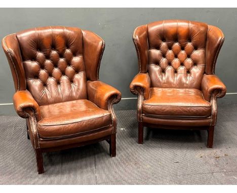 A pair of brown leather button back wing armchairs106 x 88 x 73cm