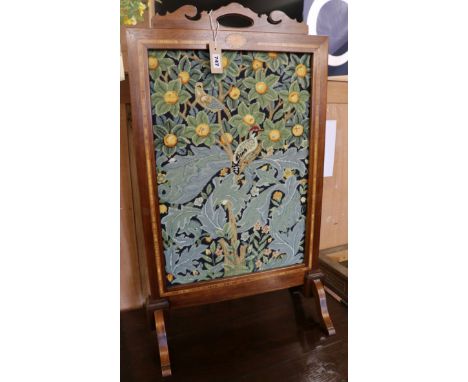 An Edwardian inlaid mahogany firescreen inset woolwork panel in a William Morris-style bird and fruit design