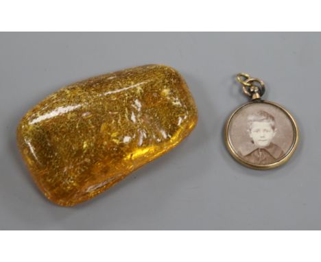 A circular yellow metal locket with photographic portrait and lock of hair verso and a piece of amber, approx 6 x 4cm