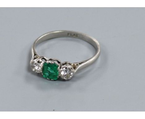 A platinum, emerald and diamond three stone ring, size O.