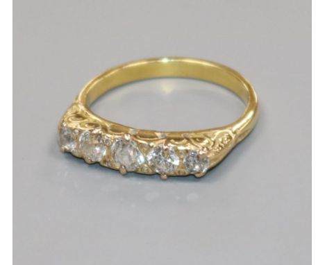 A yellow metal and graduated five stone diamond half hoop ring, size N.