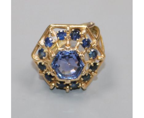 A yellow metal and sapphire set hexagonal openwork cluster ring, size J.