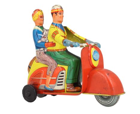 A Technofix West Germany tinplate friction-driven toy scooter, in the form of a couple with a dog riding on a bright Vespa-ty