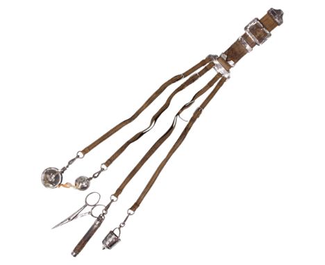 A Victorian chatelaine in tooled leather and burnished steel, carrying scissors, thimble, pinwheel, tape measure and needle c