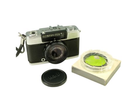An Olympus Pen EE-2 half-frame 35 mm film camera together with a boxed Hoya green photographic lens filter, former circa 1968