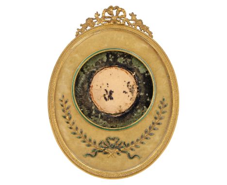 A Belle Epoque gilt metal easel-backed photograph frame, oval with ribbon-tied-bow surmount, enclosing a velvet mount with gr