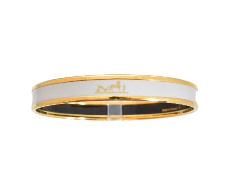 A Hermès enamel bangle bracelet,  the white enamel bangle with gold tone maker's logo and border, signed Hermès, date letter 
