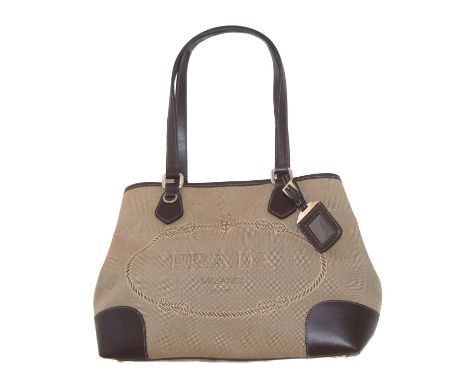 A Prada Jaquard Logo Tote bag, the beige jaquard woven canvas exterior with maker's logo detailing, brown leather double hand