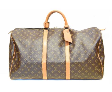 A Louis Vuitton monogram Keepall 55 luggage bag, circa 1990, the maker's monogram coated canvas with smooth leather trim, dou