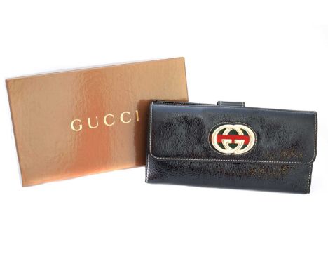 A Gucci long wallet, the black patent leather exterior with cream stitching, gold tone monogram hardware with red and green r