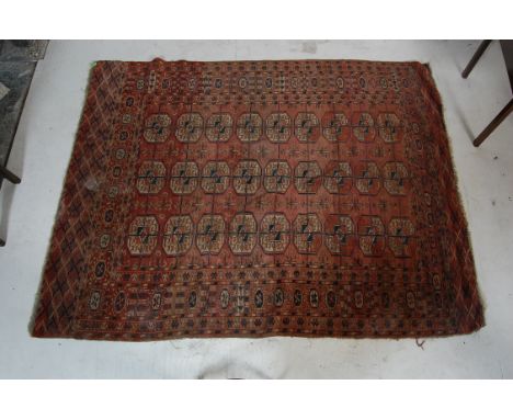 A vintage 20th century Persian Islamic rug having a red background with a central panel with geometric patterns set within a 