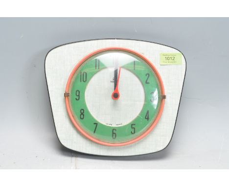 A retro vintage 1960s Jaz transistor wall clock having red frame arabic numerals to the circular green chapter ring . Makers 