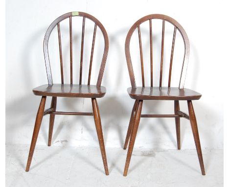 A pair of vintage retro mid 20th century beech and elm Ercol dining chairs. The chair having&nbsp;hoop backs Windsor chairs, 
