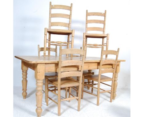 A large vintage 20th century pine table and chairs having a flared top over a recessed frieze raised on turned legs. Together