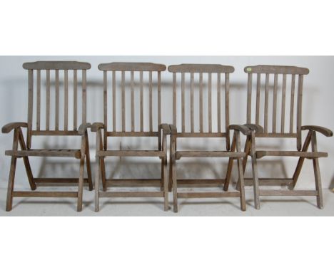 A set of four 20th century French oak folding garden chairs having a comb shaped back rest, shaped elbow rests raised on angu
