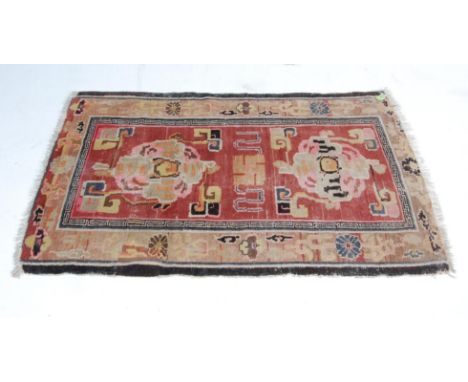 A decorative vintage 20th century handwoven Tibetan rug having vibrantly coloured yin and yang medallion set within a Greek k