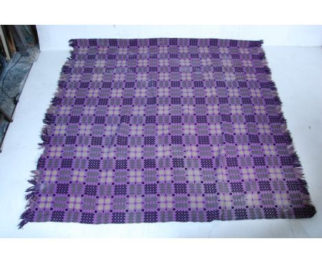 A large vintage 20th century woollen Welsh blanket having a purple background with green and black geometrics patterns throug