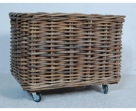 A large vintage 20th century Indonesian wicker basket of rectangular form having a cloth inner lining raised on wheels. With 