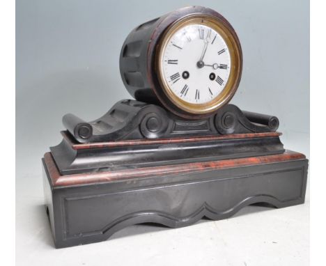 An antique 19th century slate and red marble 8 day barrel mantel clock having a white enamel face with roman numerals to the 