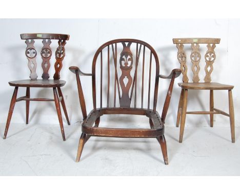 A group of three vintage retro Ercol Fleur de Lys pattern beech and elm chairs to include two dining chairs with pierced and 