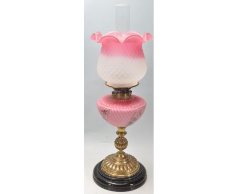 A 19th century Victorian Wright and Butler oil lamp having a floral two tone cranberry glass shade over a painted reservoir r