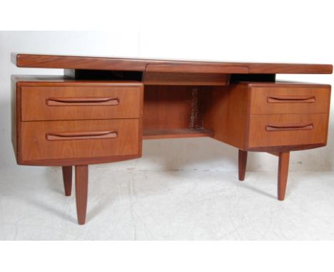 A retro vintage teak wood 20th century G Plan writing desk / dressing table having a floating shelf with hidden drawer over t