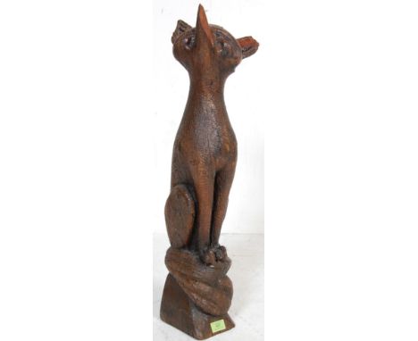 A vintage 20th century stylised wooden ornament of a fox looking up raised on a naturalistic base. Measures 69cm tall