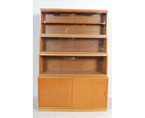 A retro vintage 1960s 20th century Simplex stacking bookcase having a three tiered glass fronted sliding door lawyers bookcas