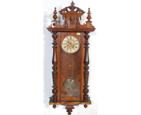 An early 20th century eight day mahogany cased Vienna regulator wall clock having a pediment top flanked by finials over a wh
