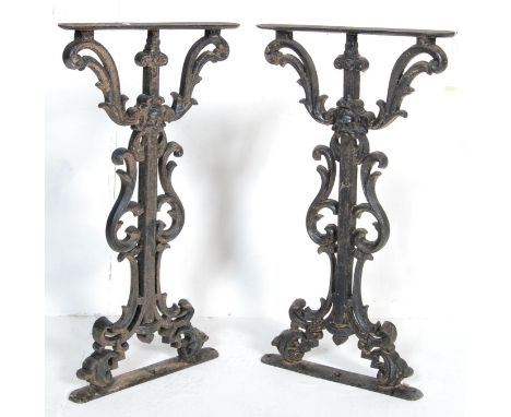 A vintage 20th century Victorian Revival pair of ebonised cast metal bench / table ends having foliate pierced decoration rai