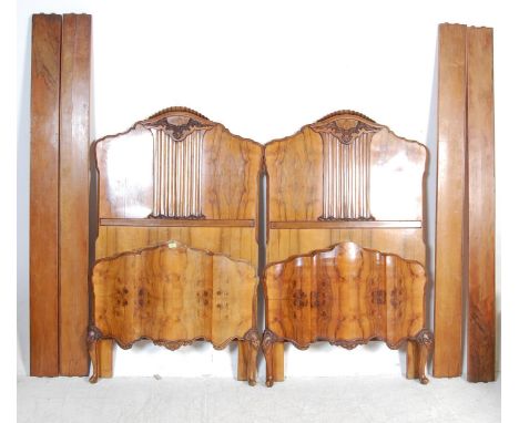 A pair of early 20th century Art Deco walnut French single beds. The beds having a tall arched headboard with carved foliate 