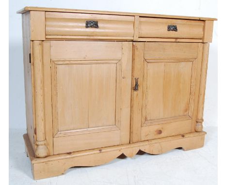 An early 20th century pine sideboard having a flared top over a pair of drawers with Art Nouveau style handles over a double 