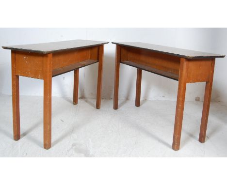 A pair of two vintage late 20th century school desks / tables of rectangular form having a melamine top with double sided she