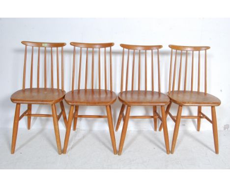 A set of four retro vintage beech and elm dining chairs having a comb back rest over a saddle seat raised on turned legs unit