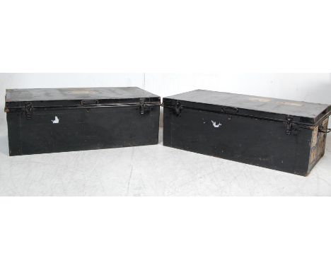 A collection of three vintage industrial 20th century steamer trunks to include two ebonised metal trunks with carry handles 