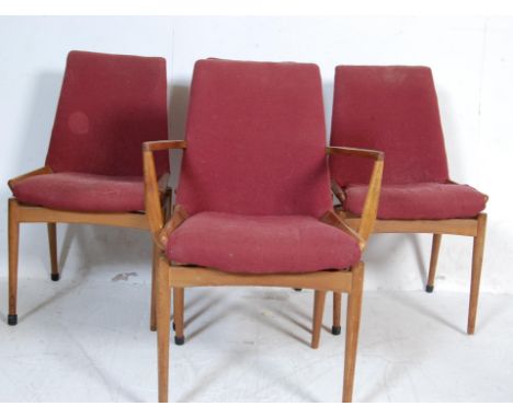 A set of four retro vintage teak wood chairs having burgundy red seats and backrests with show wood frames raised on circular